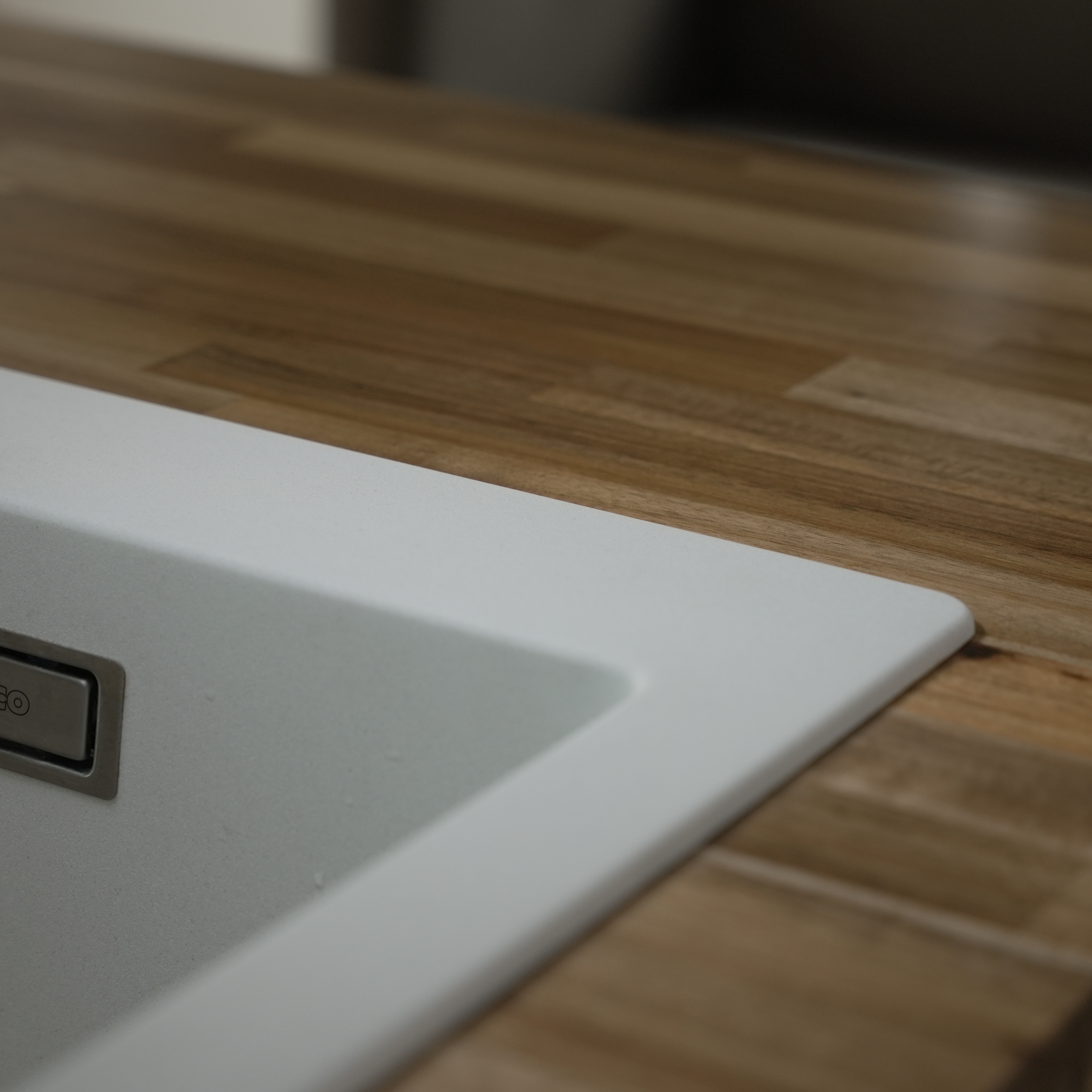 クォーツシンク シングル ホワイト KB-KC031-02-G173 オーバーシンクの場合、シンクの縁は5mmの立ち上がりになります。天板の小口に水かかからないため、メラミンや木天板と好相性です。画像はシングル ホワイトにアガチス木天板の組み合わせ